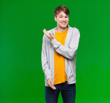 Genç sarışın adam kafası karışık ve cahil, şüpheli bir açıklamayı merak ediyor ya da kroma tuşlu duvara karşı düşünce