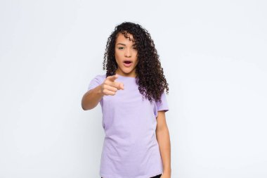 Genç siyahi bir kadın, kızgın agresif bir ifadeyle kameraya bakıyor. Öfkeli, çılgın bir patron gibi beyaz duvara bakıyor.