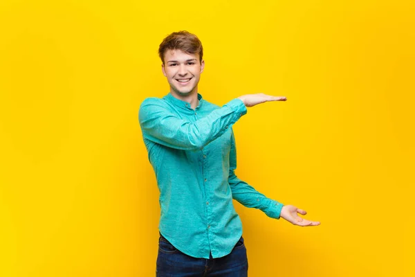 Joven Hombre Rubio Sonriendo Sintiéndose Feliz Positivo Satisfecho Sosteniendo Mostrando — Foto de Stock