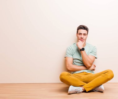 Genç Arap adam ciddi, şaşkın, kararsız ve düşünceli görünüyor. Seçenekler ve seçenekler arasında şüpheci duruyor.