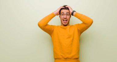 Genç Arap adam el ele tutuşuyor, ağzı açık, son derece şanslı, şaşırmış, heyecanlı ve mutlu.