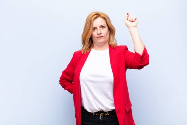 Orta yaşlı kadın ciddi, güçlü ve isyankar hissediyor, yumruğunu kaldırıyor, protesto ediyor ya da devrim için savaşıyor.