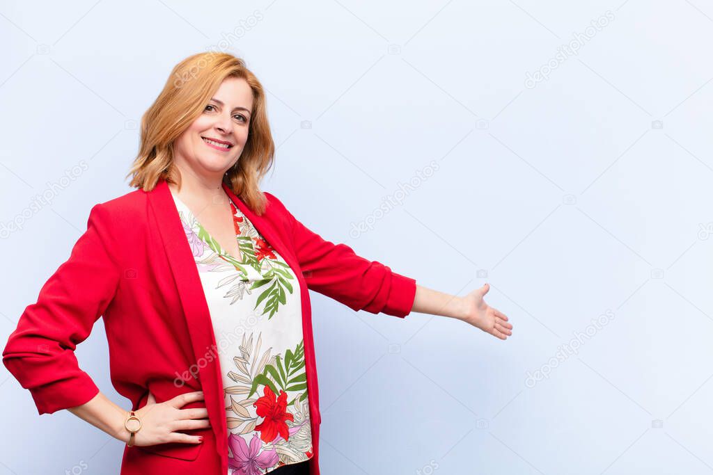 middle age woman feeling happy and cheerful, smiling and welcoming you, inviting you in with a friendly gesture
