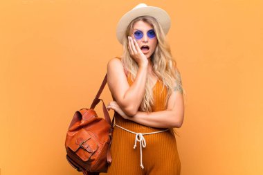  Şok ve inançsızlıkla ağzı açık, elleri yanakları ve kolları çaprazlanmış, sersemlemiş ve şaşkın.