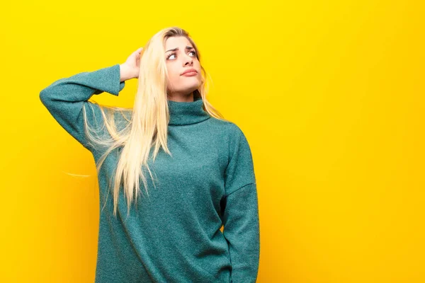 Jovem Mulher Loira Bonita Sentindo Intrigado Confuso Arranhando Cabeça Olhando — Fotografia de Stock