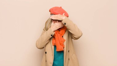 Yaşlı ya da orta yaşlı güzel bir kadın iki eliyle kameraya hayır diyerek yüzünü kapatıyor! Resimler reddediliyor ya da yasaklanıyor