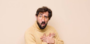 Genç havalı adam üzgün, incinmiş ve kalbi kırık görünüyor, iki elini de kalbe yakın tutuyor, ağlıyor ve yassı duvara karşı depresyona giriyor.