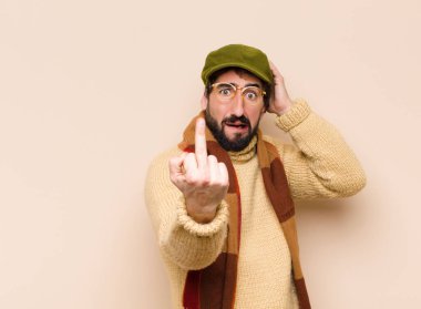 Genç havalı sakallı adam kışkırtıcı, agresif ve müstehcen hissediyor. İsyankar bir tavırla orta parmağını hareket ettiriyor.