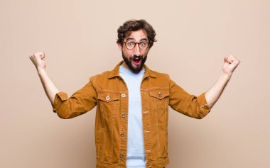 Genç, havalı ve çılgın adam yassı duvara yaslanmış.