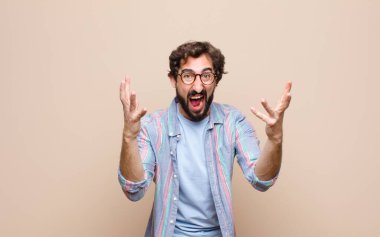 Genç sakallı adam yassı duvara yaslandı.