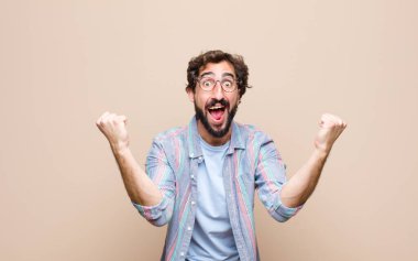 Genç sakallı adam yassı duvara yaslandı.