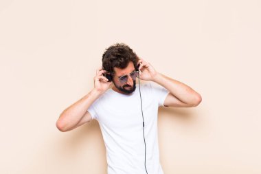 Genç havalı sakallı adam. bir kulaklıkla müzik dinlemek
