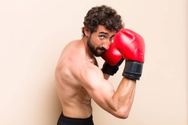 Boks eldivenli ve dövüşen sakallı genç bir adam. fitness 