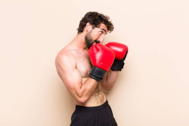 Boks eldivenli ve dövüşen sakallı genç bir adam. fitness 