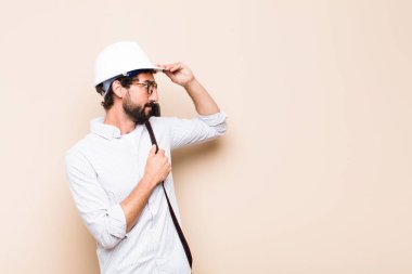 Genç sakallı mimar kafası karışmış ya da düşünüyor. 