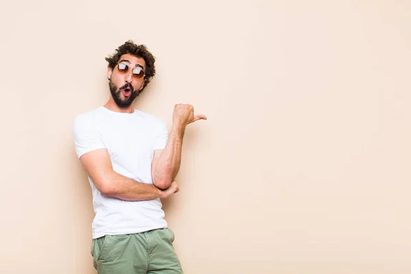 Young Cool Bearded Man Surprised Pointing Side Royalty Free Stock Photos