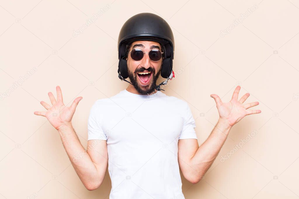young cool bearded man surprised with a helmet. motorbike rider concept