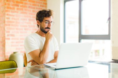 Genç sakallı bir adam. Tereddüt eden, düşünen, dudağını ısıran, kendine güveni olmayan ve gergin bir adam.