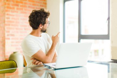 Bilgisayarlı genç sakallı adam fotokopi alanında duran ve objeyi işaret eden dikiz aynası.