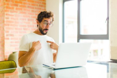 Dizüstü bilgisayarı olan genç sakallı adam mutlu, şaşkın ve gururlu hissediyordu. Heyecanlı ve şaşkın bir bakışla kendini gösteriyordu.