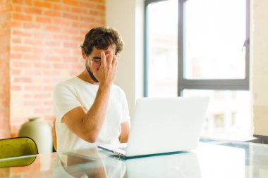 Laptoplu sakallı genç adam gülüyor ve alnına şaplak atıyor. Unuttum ya da aptalca bir hataydı. 