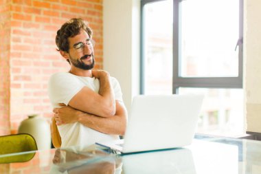 Dizüstü bilgisayarı olan genç sakallı bir adam aşık oluyor, gülümsüyor, sarılıyor ve kendine sarılıyor, bekar kalıyor, bencil ve benmerkezci oluyor.