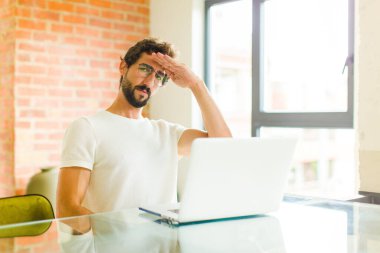 Bilgisayarlı genç sakallı adam kameraya askeri bir selamlama ile selam veriyor. Şeref ve vatanseverlik adına.