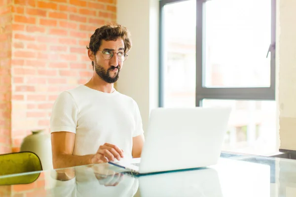 Jovem Barbudo Homem Com Laptop Olhando Confuso Confuso Querendo Saber — Fotografia de Stock