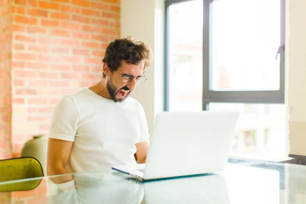 Dizüstü Bilgisayarlı Genç Sakallı Bir Adam Agresif Bir Şekilde Bağırıyor — Stok fotoğraf