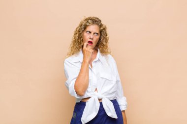 Şaşırmış, gergin, endişeli ya da korkmuş bakışları olan orta yaşlı bir kadın fotokopi alanına doğru bakıyor.