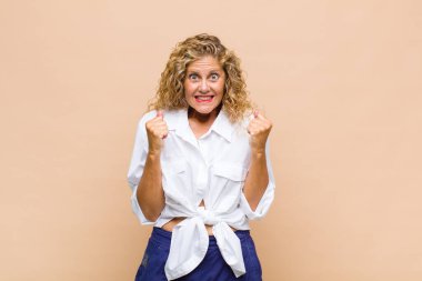 Orta yaşlı kadın şaşkın, heyecanlı ve mutlu hissediyor, gülüyor ve başarıyı kutluyor,!