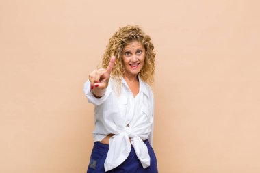 Orta yaşlı bir kadın gülümsüyor ve arkadaş canlısı görünüyor. Bir numara ya da ilk eli önde, geriye doğru sayıyor.