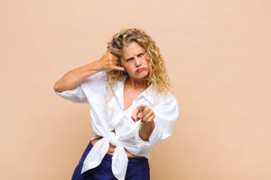 Orta yaşlı bir kadın neşeli bir şekilde gülümsüyor ve kamerayı işaret ediyor. Sonra seni arıyor, telefonla konuşuyor.