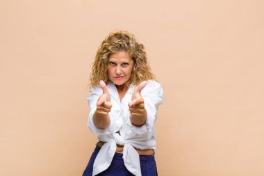 Orta yaşlı bir kadın kendini mutlu, havalı, tatmin olmuş, rahat ve başarılı hissediyor, kameraya bakıyor, seni seçiyor.