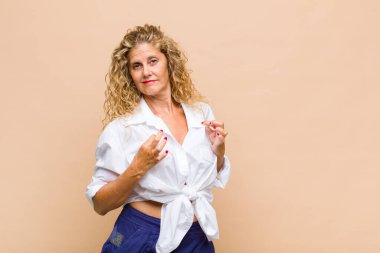 Orta yaşlı bir kadın kibirli, başarılı, pozitif ve gururlu görünüyor.