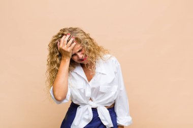 Orta yaşlı bir kadın gülüyor ve alnına şaplak atıyor. Unuttum ya da aptalca bir hataydı. 