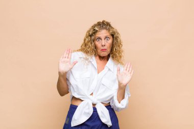 Orta yaşlı bir kadın gergin, endişeli ve endişeli görünüyor. Benim hatam olmadığını söylüyor. Yoksa ben yapmadım. 