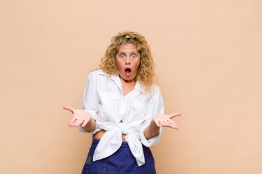 Orta yaşlı bir kadın inanılmaz bir sürprizle şaşkın ve şaşkın.