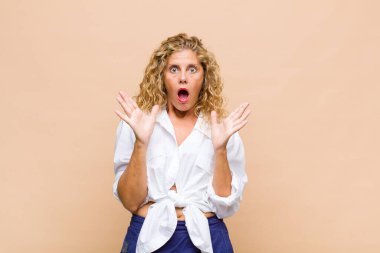 Orta yaşlı kadın şaşkın ve şaşkın bakıyor, inanılmaz bir şey fark ettiğinde çene şaşkın