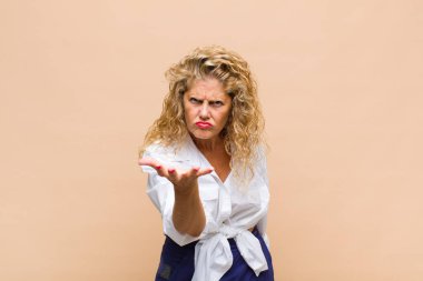 Orta yaşlı bir kadın sinirli, sinirli ve sinirli görünüyor. Senin neyin var? 