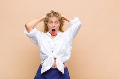 Orta yaşlı kadın mutlu, kaygısız, arkadaş canlısı ve rahat görünüyor. Hayattan ve başarıdan keyif alıyor, olumlu bir tavırla.