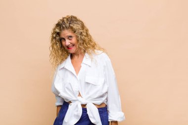 Büyük, dostane, kaygısız bir gülümsemesi olan orta yaşlı bir kadın. Olumlu, rahat ve mutlu görünüyor.