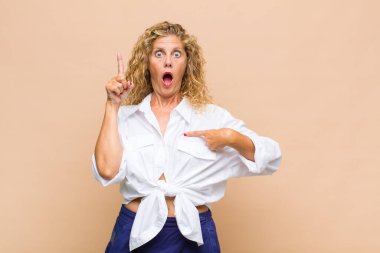 Orta yaşlı bir kadın gururlu ve şaşırmış, kendine güvenen, kendini bir numara gibi hisseden.