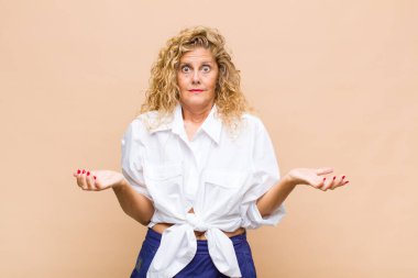 Orta yaşlı bir kadın bilgisiz ve kafası karışık, hangi seçeneği seçeceğinden emin değil, merak ediyor.