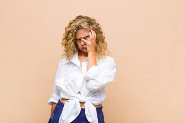 Orta yaşlı bir kadın yorgun, sıkıcı ve sıkıcı bir işten sonra sıkılmış, hayal kırıklığına uğramış ve uykulu hisseder.