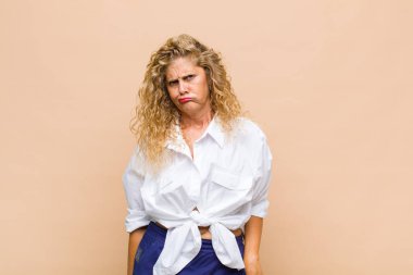 Orta yaşlı bir kadın aptal ve komik görünüyor. Şaşı bakışlı, şakacı ve şakacı.