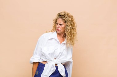 Middle age woman feeling puzzled and confused, with a dumb, stunned expression looking at something unexpected