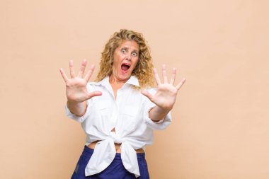 Orta yaşlı bir kadın sersemlemiş ve korkmuş hissediyor. Korkutucu bir şeyden korkuyor. Elleri açık ve uzak durun diyor.