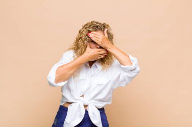 Orta yaşlı kadın kameraya hayır diyen iki eliyle yüzünü kapatıyor! Resimler reddediliyor ya da yasaklanıyor