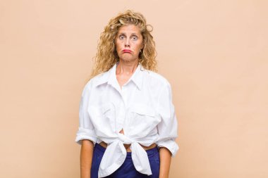 Orta yaşlı bir kadın üzgün ve stresli, kötü bir sürpriz yüzünden üzgün, olumsuz, endişeli bir bakışla